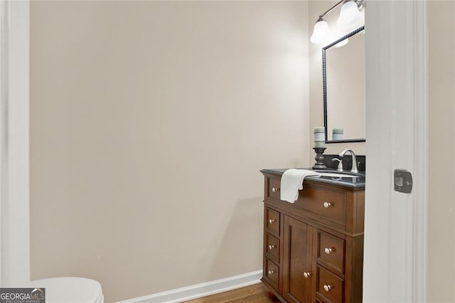 bathroom featuring hardwood / wood-style flooring, vanity, and toilet