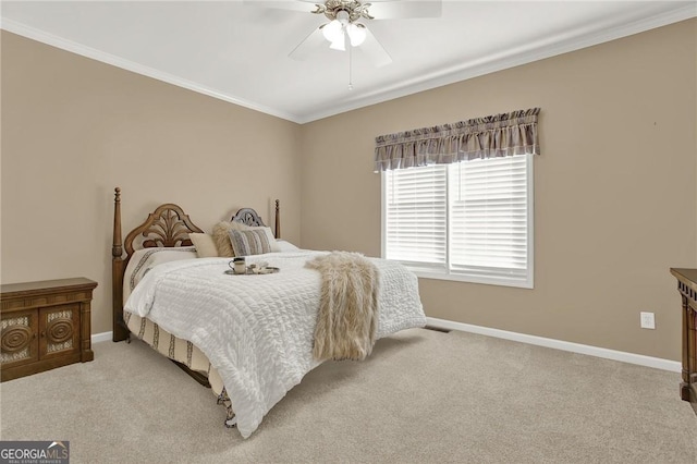 carpeted bedroom featuring ceiling fan and crown molding