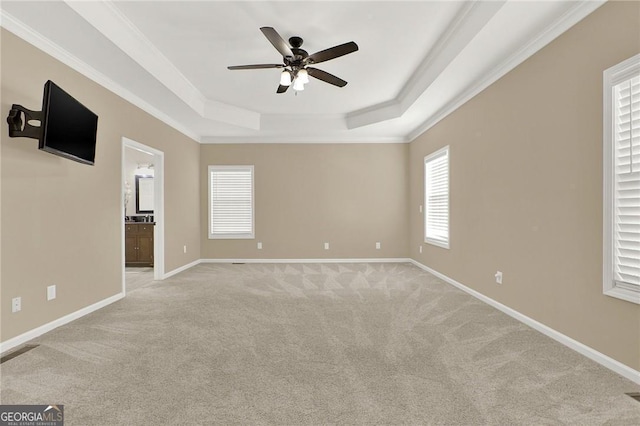 interior space with a tray ceiling, ceiling fan, and crown molding