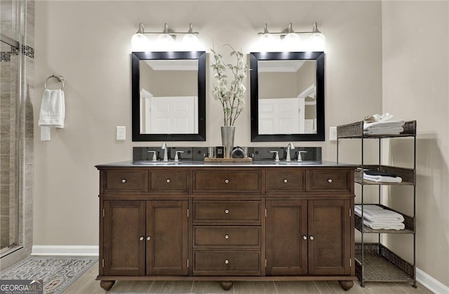 bathroom featuring vanity, a shower with shower door, and crown molding