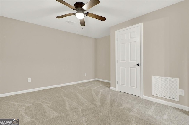 empty room featuring ceiling fan and light colored carpet