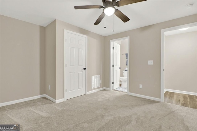 unfurnished bedroom featuring ensuite bathroom, ceiling fan, and light carpet