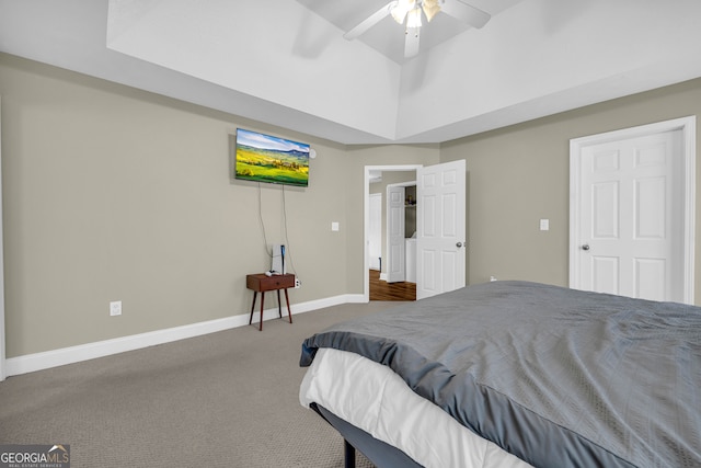 carpeted bedroom featuring a raised ceiling and ceiling fan