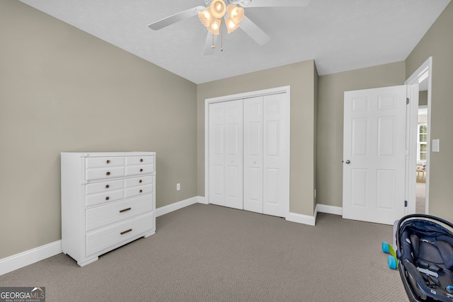 unfurnished bedroom featuring dark colored carpet, ceiling fan, and a closet