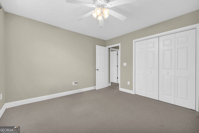 unfurnished bedroom featuring dark colored carpet, a closet, and ceiling fan