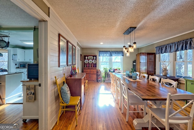 dining space featuring a textured ceiling and light hardwood / wood-style floors