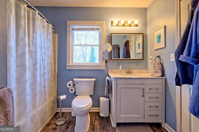 bathroom featuring a shower with curtain, vanity, a textured ceiling, wood-type flooring, and toilet