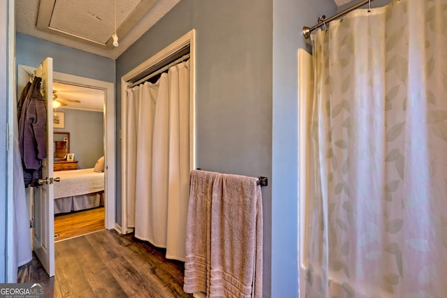 bathroom featuring curtained shower, hardwood / wood-style floors, ceiling fan, and a textured ceiling