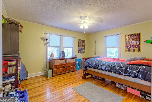 bedroom featuring ceiling fan, a textured ceiling, and multiple windows