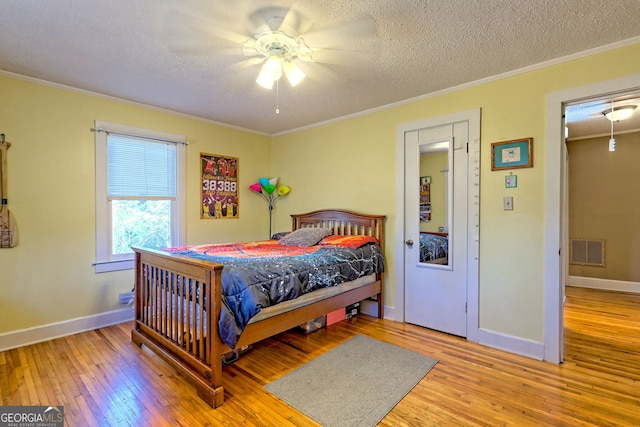 bedroom featuring ceiling fan, light hardwood / wood-style flooring, and ornamental molding