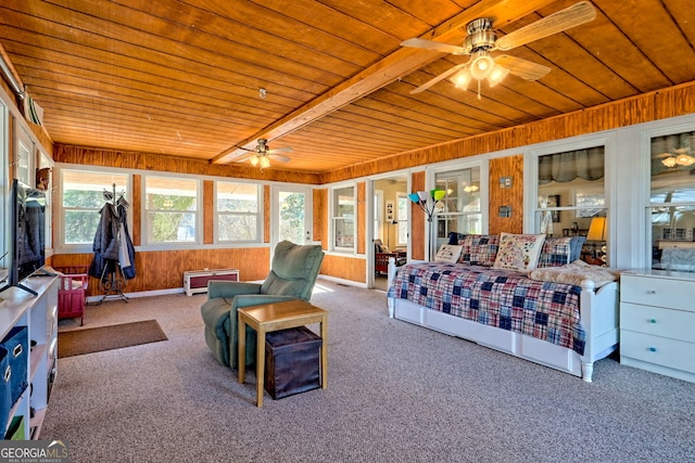 carpeted bedroom with beamed ceiling, ceiling fan, wooden walls, and wood ceiling