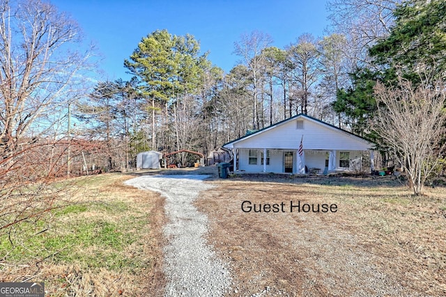 ranch-style house with covered porch and an outbuilding