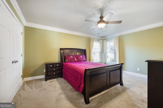 bedroom featuring crown molding, ceiling fan, a closet, and light carpet