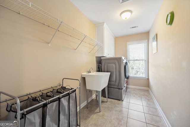 washroom featuring cabinets, washer / dryer, and light tile patterned floors