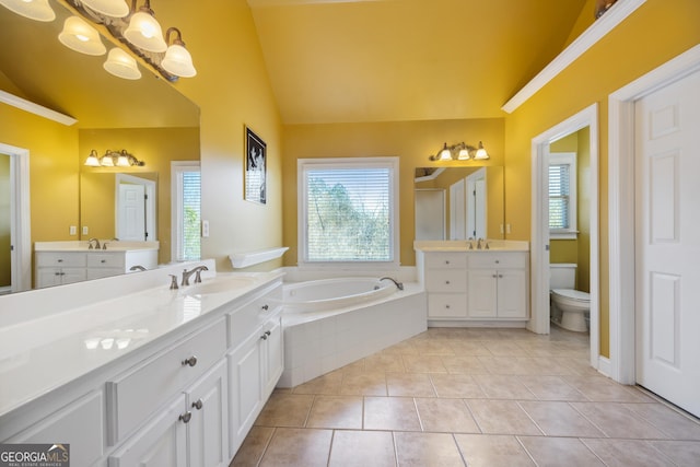 bathroom featuring vanity, vaulted ceiling, tile patterned flooring, toilet, and tiled tub