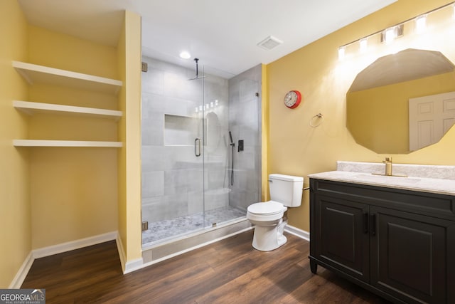 bathroom with toilet, vanity, a shower with door, and hardwood / wood-style flooring