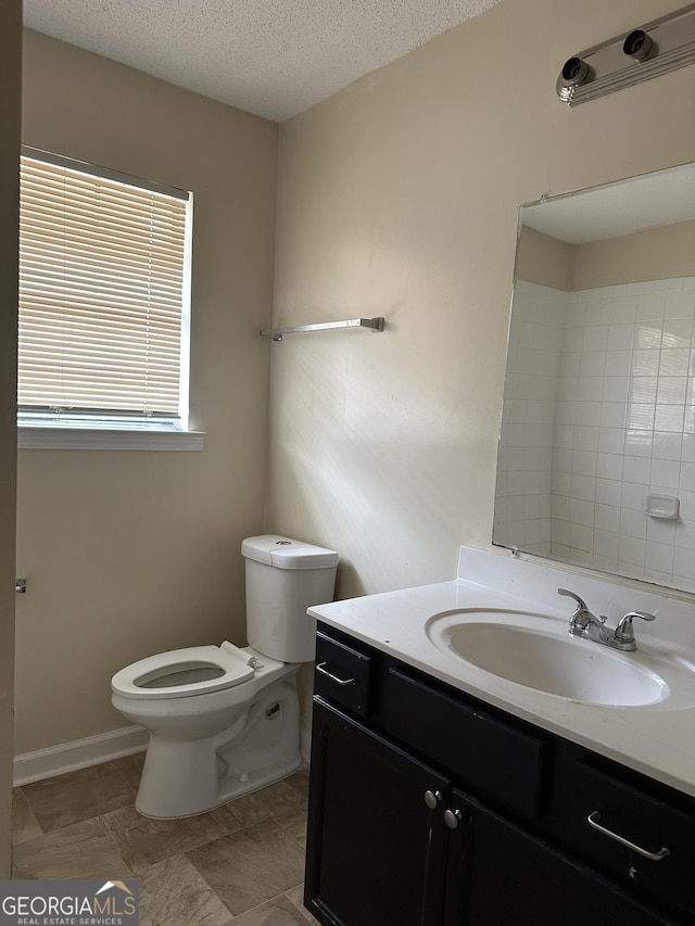 bathroom with toilet, a textured ceiling, and vanity