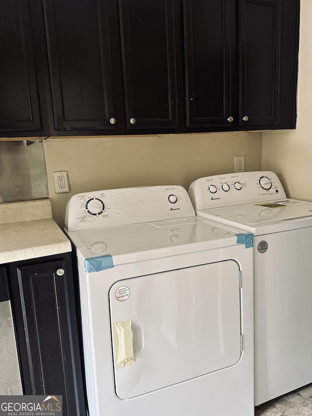 washroom featuring washing machine and dryer and cabinet space