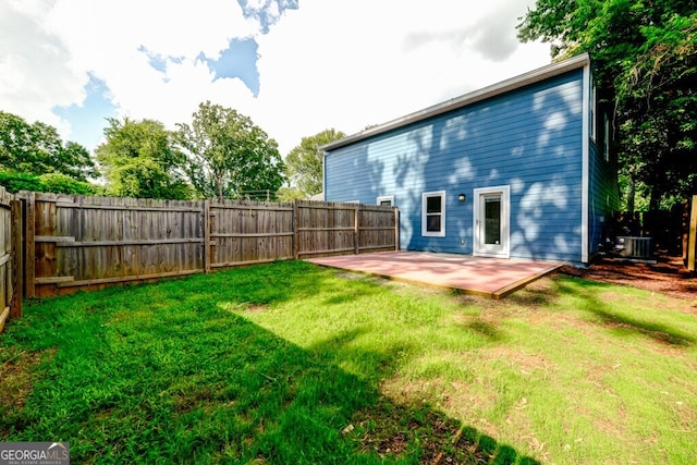 rear view of house with a lawn, central AC unit, and a patio area