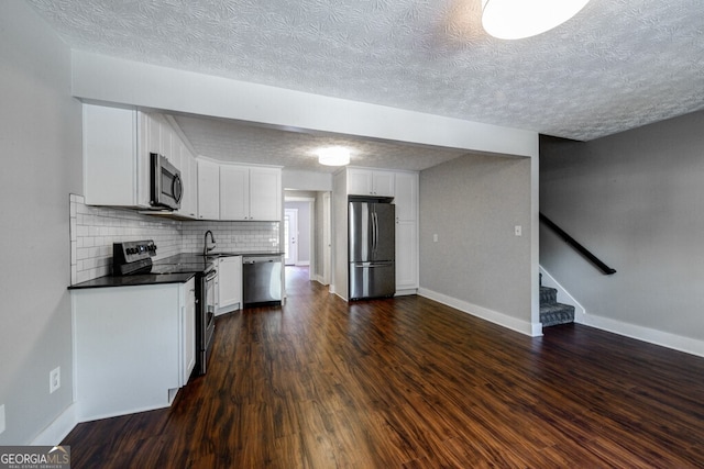 kitchen with white cabinetry, sink, stainless steel appliances, tasteful backsplash, and dark hardwood / wood-style flooring