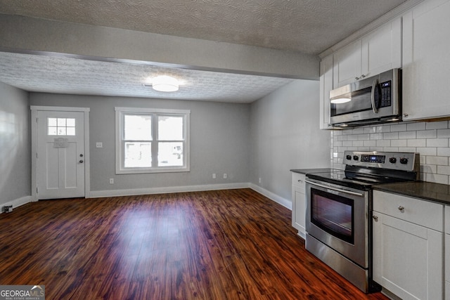 kitchen with backsplash, white cabinetry, dark hardwood / wood-style floors, and appliances with stainless steel finishes