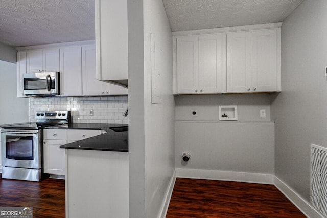 kitchen featuring backsplash, white cabinets, dark hardwood / wood-style floors, a textured ceiling, and stainless steel appliances