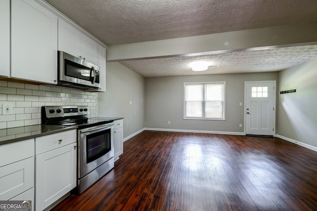 kitchen with dark hardwood / wood-style flooring, backsplash, stainless steel appliances, and white cabinetry