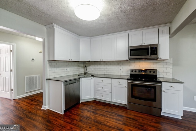 kitchen featuring backsplash, sink, white cabinetry, and stainless steel appliances