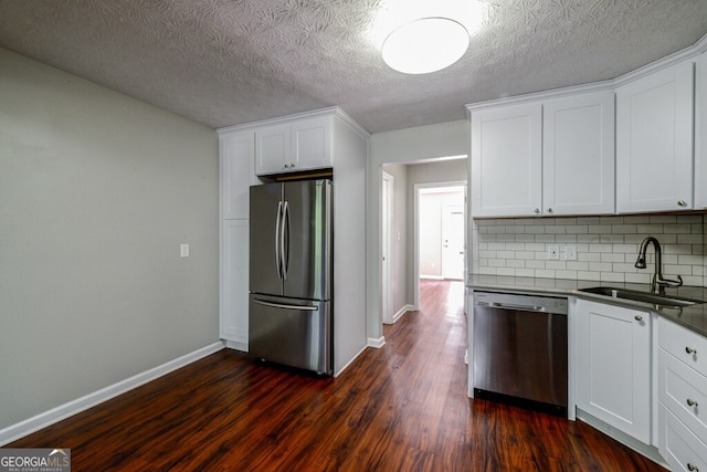 kitchen with tasteful backsplash, white cabinetry, sink, and appliances with stainless steel finishes