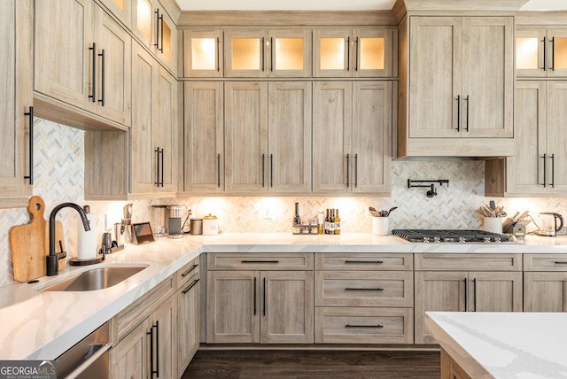 kitchen with light brown cabinets, sink, decorative backsplash, appliances with stainless steel finishes, and light stone counters