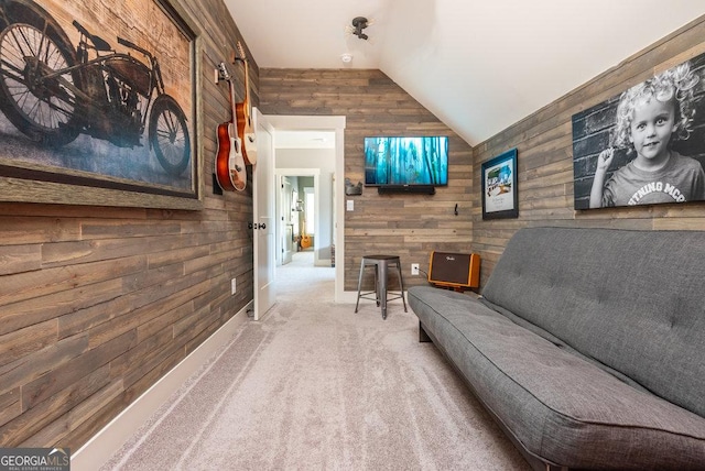 carpeted home theater room with vaulted ceiling and wooden walls