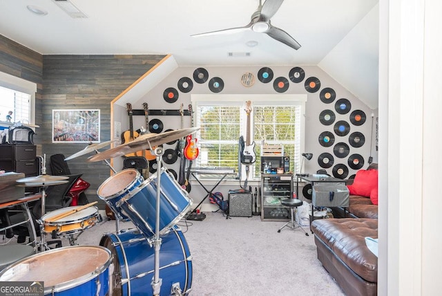 interior space with carpet flooring, ceiling fan, and wood walls