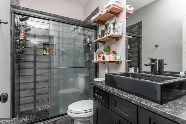 bathroom with vanity, toilet, and an enclosed shower