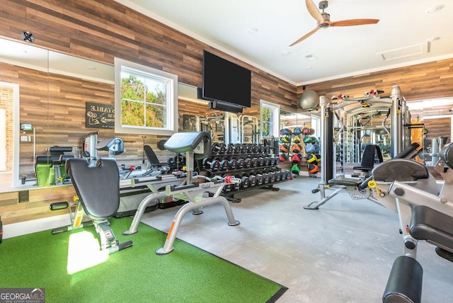 gym with ceiling fan and wood walls