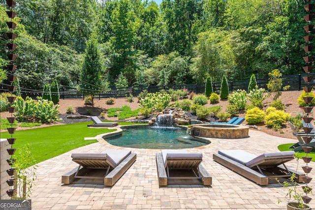 view of pool featuring pool water feature and an in ground hot tub