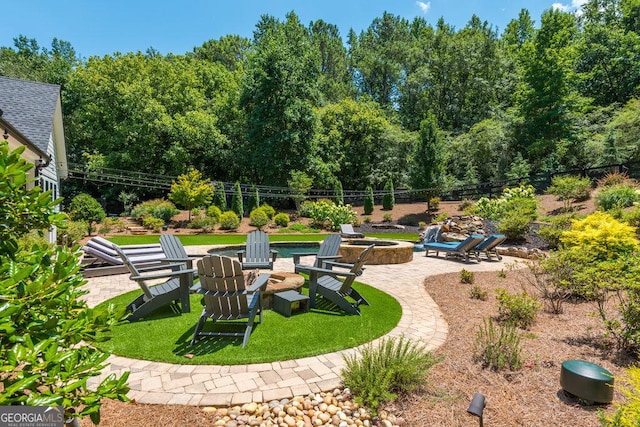 view of home's community with a lawn, a patio, and a fire pit