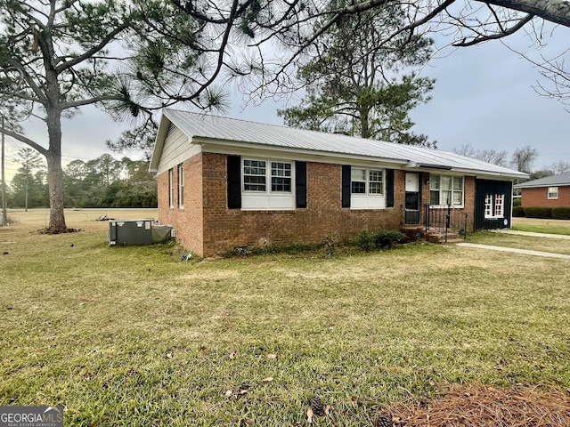 view of front of property featuring central AC and a front lawn