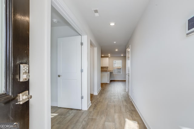 corridor with light hardwood / wood-style flooring