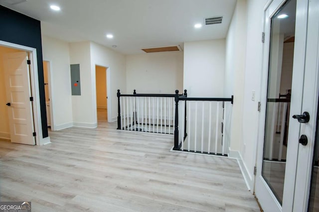 hallway featuring light hardwood / wood-style floors and electric panel