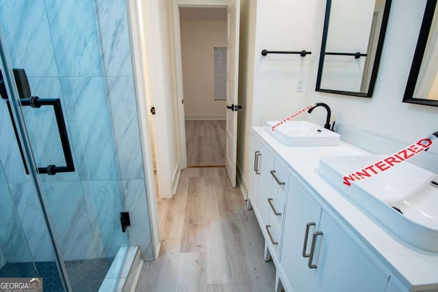 bathroom featuring hardwood / wood-style floors, vanity, and an enclosed shower