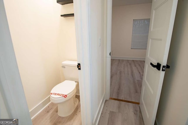 bathroom featuring hardwood / wood-style flooring and toilet