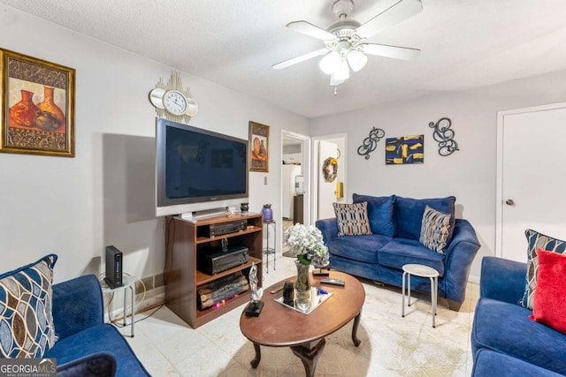 living room featuring ceiling fan and a textured ceiling