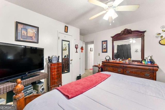 bedroom with ceiling fan and a textured ceiling