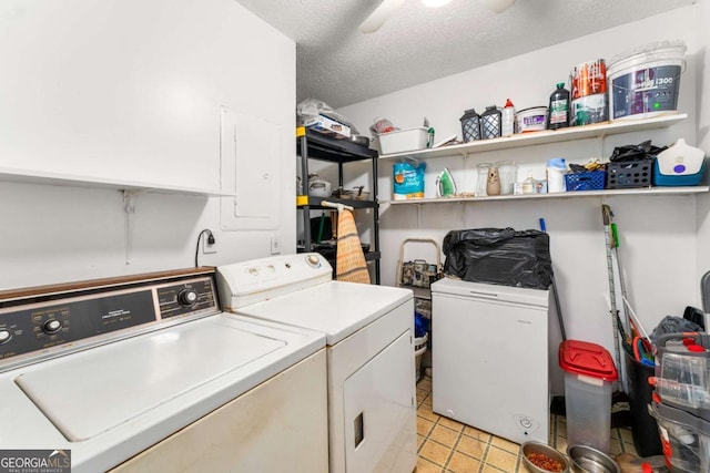 clothes washing area with washing machine and dryer, ceiling fan, light tile patterned floors, and a textured ceiling