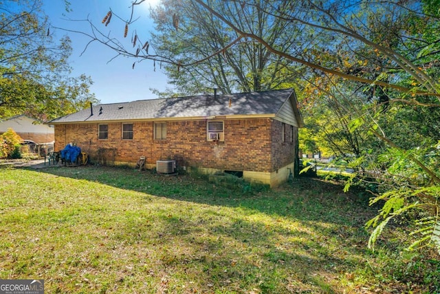 back of house with central AC and a lawn