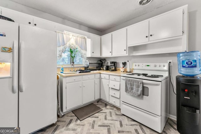 kitchen with a textured ceiling, white cabinetry, sink, and white appliances