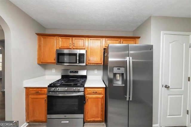 kitchen with a textured ceiling and stainless steel appliances