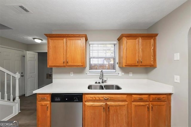 kitchen featuring a textured ceiling, dishwasher, and sink