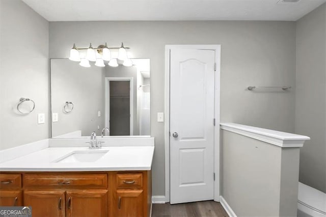 bathroom featuring vanity, hardwood / wood-style flooring, and toilet