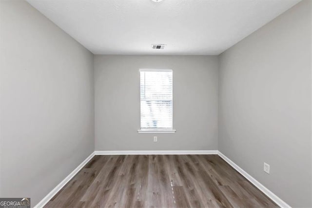 unfurnished room with dark wood-type flooring